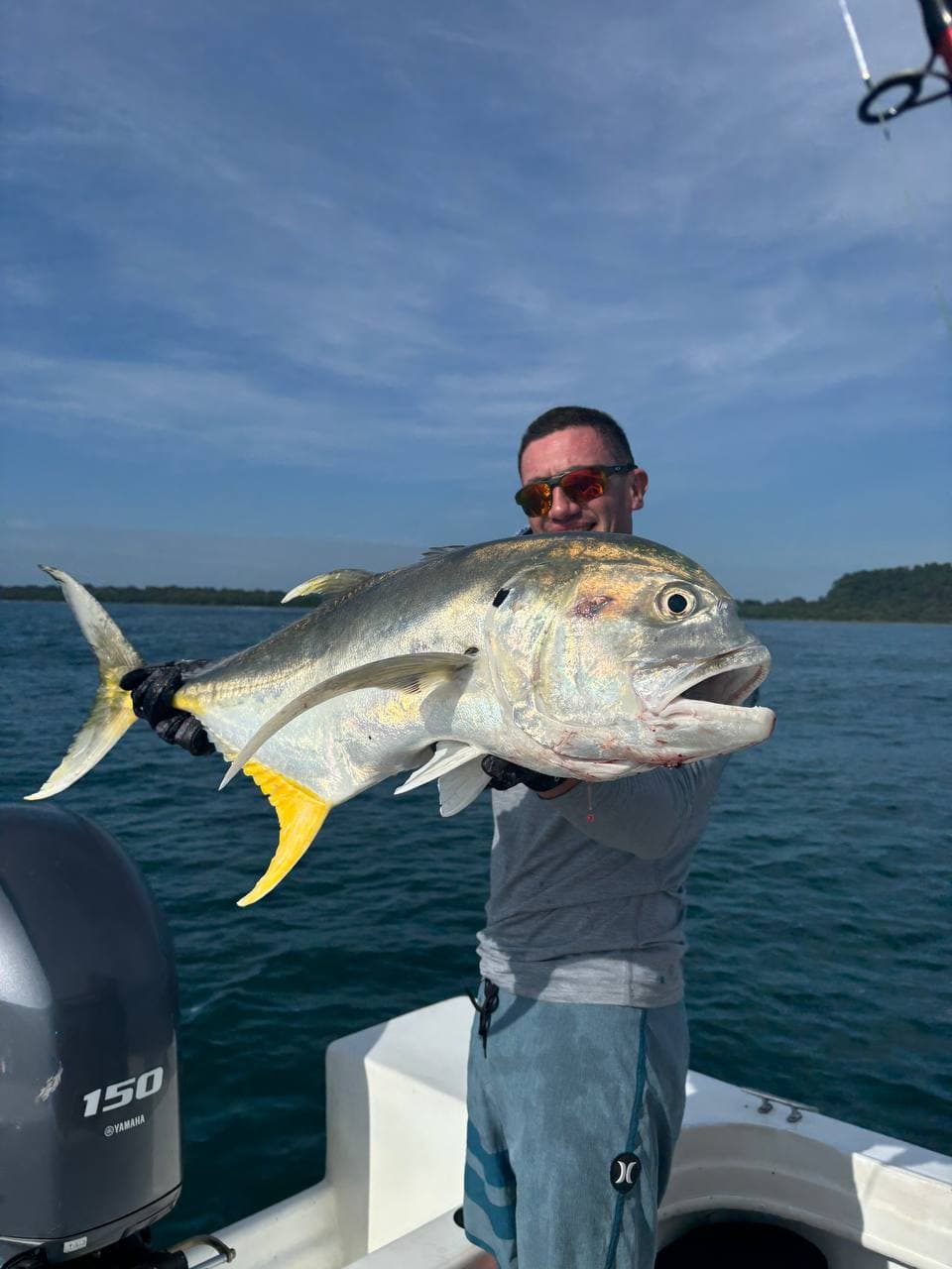 Angler holding a large Jack Crevalle from a sport fishing boat